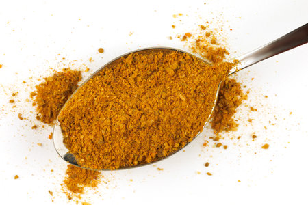 Curry powder seasoning in a metal spoonの写真素材
