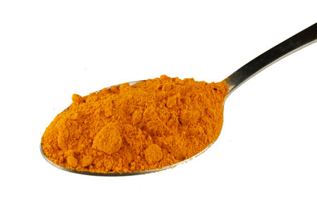 Turmeric spice in a metal spoonの写真素材