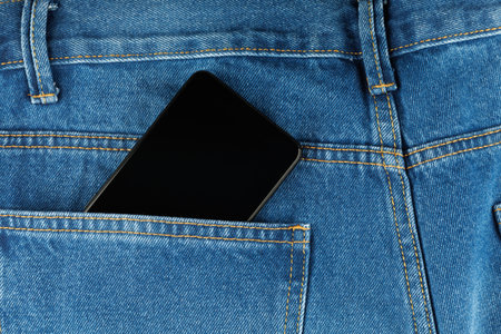 Black smartphone in pants pocketの写真素材