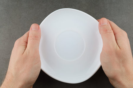Hands hold empty white plate.の写真素材
