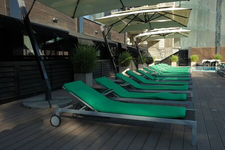 Green sunbeds and parasol at the pool. Furniture on the beach, Furniture outdoor