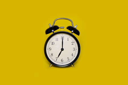 Clock alarm clock on a bright yellow backgroundの写真素材