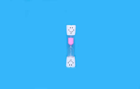 Childrens hourglass on a bright blue backgroundの写真素材