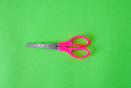 Scissors on a bright green backgroundの写真素材