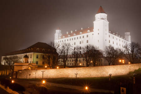 illuminated bratislava castle in the autumn fogの写真素材