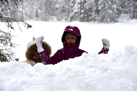 Girl with mother roll and trundle in high snow