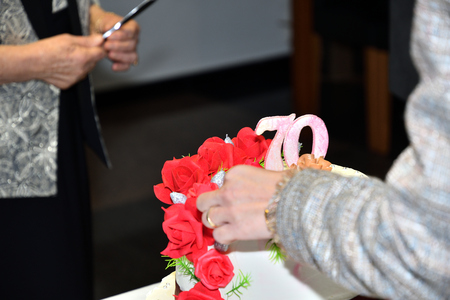 family celebration and slicing cakes for the 70th anniversaryの写真素材