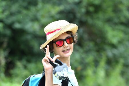 Girl to pose in a summer hat during hot weather by the riverの写真素材