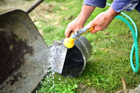 After finishing the work, the mason cleans pail tools with water