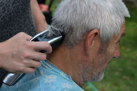 Home haircut using an electric man with an electric man with gray hairの写真素材