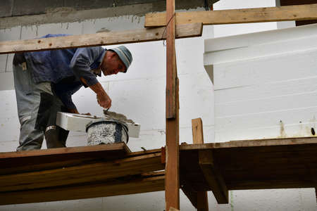 Mason works how to insulate the wall with nails and polystyrene