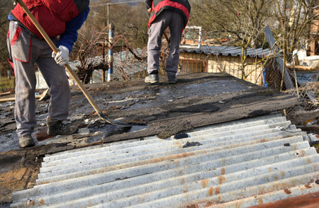 Roof workers remove metal roof during demolitionの写真素材