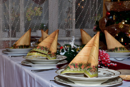 Festively set Christmas table in the home for Christmas dinner in the eveningの写真素材