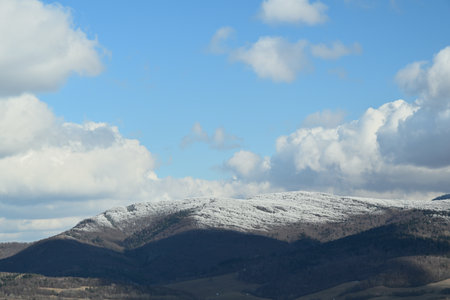 Snow-capped peaks of hills and mountains in an agricultural landscape