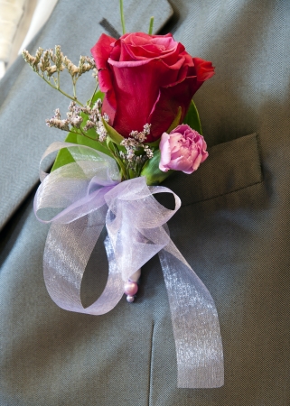 Wedding flower, rose and carnation, in a lapel button on a suit of groom の写真素材