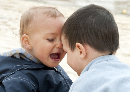 Two children,  small brother boys playing together outdoors.の写真素材