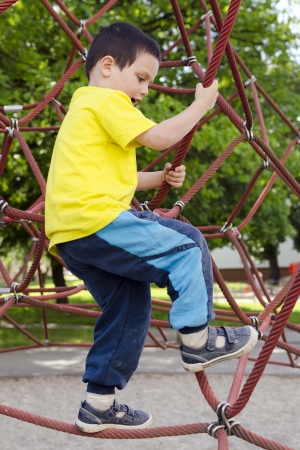 Child playing in playground on a modern rope climibing equipment.の写真素材