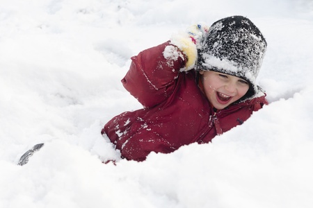 Happy child, boy or girl, playing in a deep fresh snow in winter の写真素材