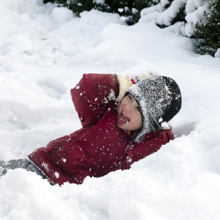 Happy child, boy or girl, playing in a deep fresh snow in winter の写真素材