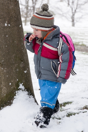 Child playing with first snow in a park.の写真素材