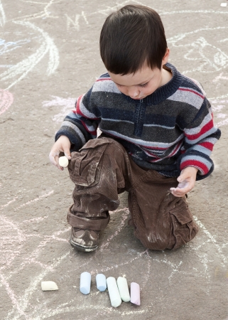 Child chalk drawing on the pavement outside. の写真素材