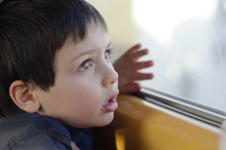Child travelling by train looking from the windowの写真素材