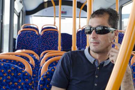Man passanger siting on city bus, traveling by modern public transport.の写真素材
