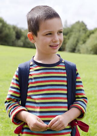 Portrait of a child boy standing on a meadow on a nature walk.の写真素材