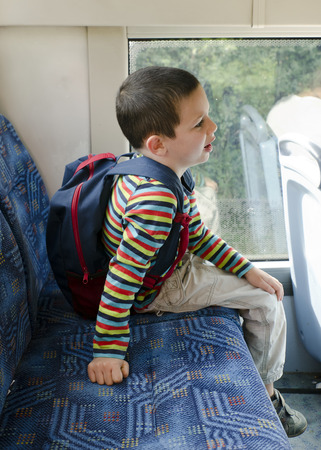 Child with school bag travelling on a public transport city bus .の写真素材