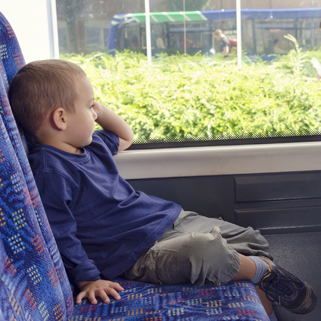 Child  travelling on a public transport city bus .の写真素材