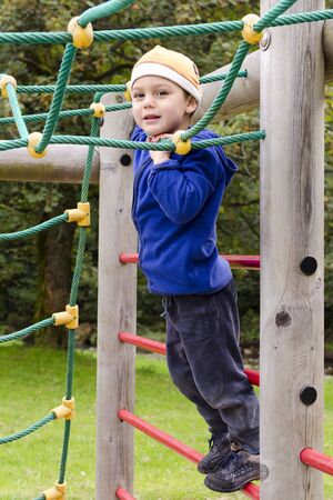 Child playing on a climbing frame at children playground at park.の写真素材
