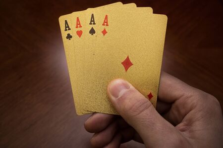 four aces in hand, golden card in hands, four playing cards in the right hand, quads of aces, four...
