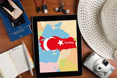 overhead view of traveler's accessories and map of Turkey on tablet, travel concept background, map of Turkey on tablet display and essential vacation items, passports, notepad and tourist country mapの写真素材