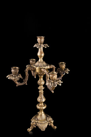 bronze chandelier at the bottom left of the photo on a black background, candlestick bronze photo, ancient gold chandelier, antique chandelier on a black backgroundの写真素材
