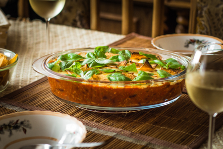Food chili con carne in a heat-resistant dish decorated with lots of fresh basil and nachosの写真素材