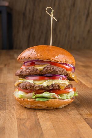 Hamburger on wooden background. For fast food restaurant design or fast food menuの写真素材