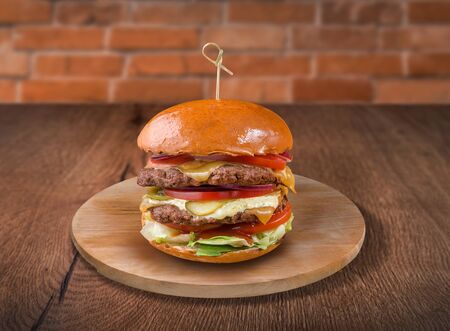 Hamburger on wooden background. For fast food restaurant design or fast food menuの写真素材