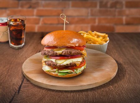 Beef burger on wooden background. For fast food restaurant design or fast food menuの写真素材