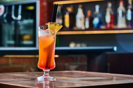 Drink cocktail with pinapple in a night bar. Blurry pub background. Copy spaceの写真素材