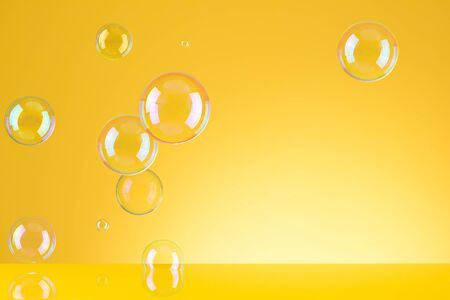 Soap bubbles on yellow background with copyspaceの写真素材