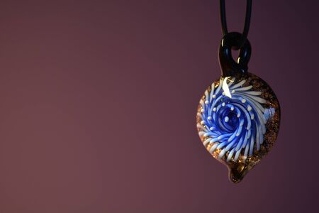 Glass pendant against a purple backdrop, horizontalの写真素材