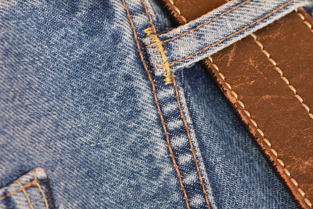 Blue jeans with a leather belt, close-up detail