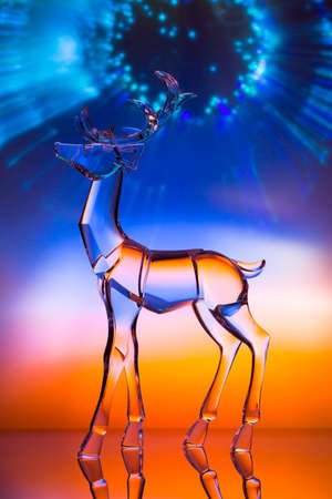 Crystal reindeer statuette in front of colorful Aurora with reflectionsの写真素材