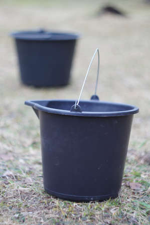 black bucket on grass in the gardenの写真素材
