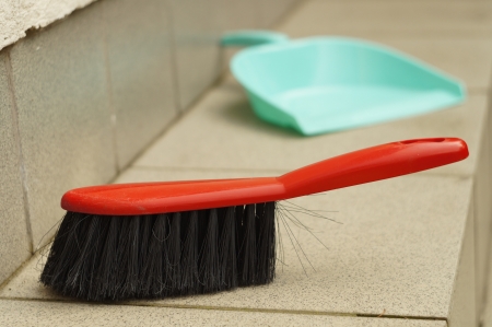 Brush and dustpan outdoors outside a houseの写真素材