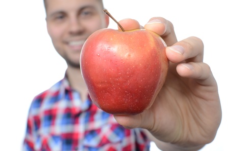 Young smiling man with fresh apple isolated on whiteの写真素材