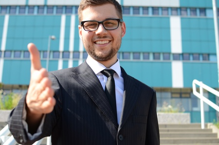 young businessman in suit against modern buildingの写真素材