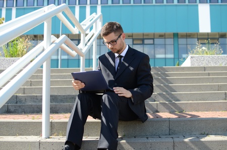 young businessman in suit against modern building