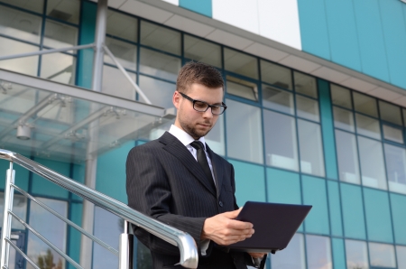 young businessman in suit against modern buildingの写真素材