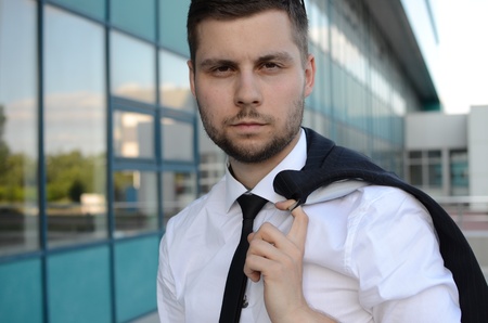 young businessman in suit against modern buildingの写真素材